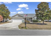 Charming single-story home featuring an attached two-car garage, a well-manicured lawn, and mature trees on a sunny day at 1336 Gailard Dr., Conway, SC 29526