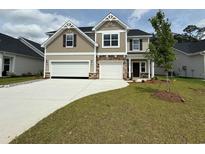 Charming two-story home boasts a manicured lawn, a two-car garage, and beautiful craftsman-style architecture at 152 Azure Loop, Myrtle Beach, SC 29588