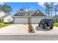 Charming home featuring a two-car garage and well-maintained front yard with attractive landscaping and a sunny curb appeal at 1586 Jardine Loop, Little River, SC 29566
