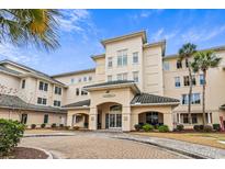 Elegant condominium complex featuring a stone paved driveway and coastal landscaping under a bright sky at 2180 Waterview Dr. # 713, North Myrtle Beach, SC 29582