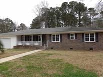 Charming brick ranch-style home with a cozy front porch and inviting curb appeal at 2415 Magnolia Lane, Little River, SC 29566