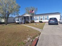 Charming single-story home featuring a welcoming porch, blue shutters, and well-maintained landscaping at 2516 Stones Edge Blvd., Little River, SC 29566