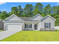 Charming single-story home featuring a two-car garage, well-manicured lawn, and inviting front entrance at 261 Six Mile Creek Dr., Georgetown, SC 29440