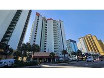 View of the building's exterior, palm trees and street in front of the building on a sunny day at 2701 N Ocean Blvd. # 1561-64, Myrtle Beach, SC 29577