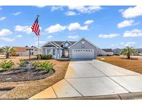 Charming single-story home with a two-car garage, beautiful landscaping, and an American flag waving in the yard at 344 Encore Circle, Myrtle Beach, SC 29579