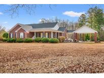 Charming brick home with a manicured lawn and porte-cochère, perfect for outdoor entertaining at 3618 Highway 430, Nichols, SC 29581