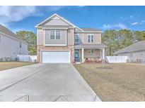 Charming two-story home featuring a two-car garage, stone accents, and a well-manicured lawn at 404 Cattle Drive Circle, Myrtle Beach, SC 29588