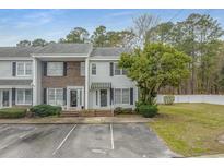 Charming townhome with brick and vinyl siding, complemented by a mature tree and convenient parking at 4115 Little River Rd. # 7F, Myrtle Beach, SC 29577