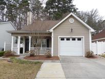 Charming home with tan siding, a front porch, and an attached one-car garage at 4406 Barcelona Ln., Little River, SC 29566