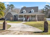 Charming brick home featuring a spacious front yard, welcoming porch, and a long driveway, perfect for curb appeal at 450 Deer Spring Loop, Georgetown, SC 29440