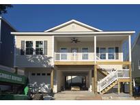 Inviting coastal home featuring a spacious covered porch, ground-level garage, and ample parking underneath the raised structure at 508 21St Ave. S, North Myrtle Beach, SC 29582