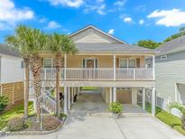 Charming stilt home with a large front porch, mature palm trees, and a spacious driveway at 511 N 21St Ave. N, North Myrtle Beach, SC 29582