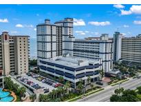 Aerial view of a resort with a multi-level parking garage and tropical landscaping at 5308 N Ocean Blvd. # 1003, Myrtle Beach, SC 29577