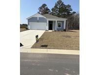 Charming one-story home with a well-manicured lawn, attached garage and inviting entryway at 619 Castillo Dr., Loris, SC 29569