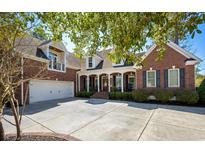 Beautiful brick home featuring an attached garage, manicured landscaping and charming front porch with columns at 915 Preservation Circle, Pawleys Island, SC 29585