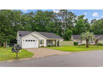 Charming single-story home with attached garage, driveway, manicured lawn, and mature trees at 945 Castlewood Dr., Conway, SC 29526