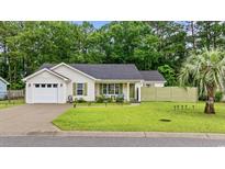 Charming single-story home with a well-maintained lawn, quaint front porch seating, and attached one-car garage at 945 Castlewood Dr., Conway, SC 29526
