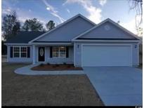 Charming single-story home featuring gray siding, a two-car garage, and a well-manicured lawn at Tbd7 Saint John Rd., Galivants Ferry, SC 29544