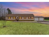 Charming single-story home featuring a large front yard and detached two-car garage at 1888 Singing Pines Dr., Conway, SC 29527