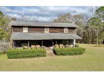 Rustic two-story home featuring a full front porch and lush green lawn at 1993 Meadowood Ln., Longs, SC 29568