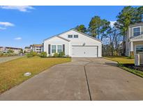 Charming one-story home featuring white siding, a two-car garage, and a well-manicured lawn at 2015 Borgata Loop, Longs, SC 29568