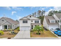 Charming two-story home with a well-manicured lawn, a two-car garage, and a welcoming front porch at 4251 Pecan St., Little River, SC 29566