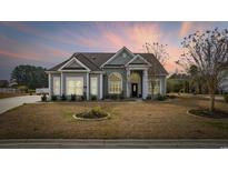 Charming single-Gathering home with manicured lawn and inviting entrance and beautiful sunset at 518 Amberview Loop, Little River, SC 29566