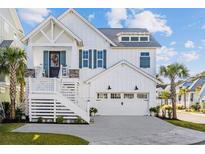 Beautiful two-story home featuring a white exterior, well-manicured landscaping, and a welcoming front porch at 5368 Ocean Village Dr., Myrtle Beach, SC 29577
