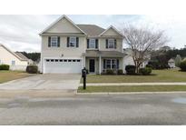 Charming two-story home featuring a two-car garage and well-manicured front lawn at 569 Ramblewood Circle, Little River, SC 29566
