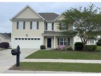 Charming two-story home featuring a two-car garage, well-manicured lawn, and lovely landscaping at 569 Ramblewood Circle, Little River, SC 29566