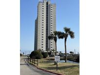 Towering condo building with well-maintained landscaping and palms under a bright blue sky at 5905 South Kings Hwy. # 1116, Myrtle Beach, SC 29575