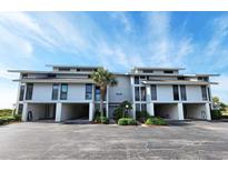 Beautiful two-story condo building with covered parking and lush landscaping at 701 Norris Dr., Pawleys Island, SC 29585