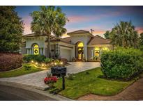 Stunning home exterior featuring a landscaped yard, inviting entrance, and lovely curb appeal at twilight at 7584 Regina Ct., Myrtle Beach, SC 29572