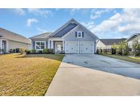 Charming single-story home featuring a two-car garage and well-manicured lawn on a sunny day at 804 Yauhannah Dr., Little River, SC 29566