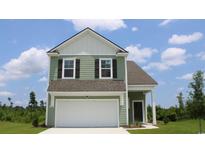 Charming two-story home with a two car garage, green siding, and classic architectural details at 8081 Bear Claw Way, Conway, SC 29526
