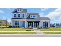 Inviting two-story home with a manicured lawn, covered porch, and stylish architectural details at 123 Tbd Joyce Dr, Longs, SC 29568