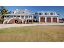 Stunning home with a sprawling lawn, brick accents, and a three-car garage with a metal roof at 2425 South Bay St., Georgetown, SC 29440