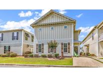 Charming two-story home featuring a well-manicured lawn, tasteful landscaping, and coastal architectural details at 382 Lumbee Circle, Pawleys Island, SC 29585