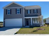 Charming two-story home with attached garage and manicured lawn on a bright sunny day at 4484 East Coast Ln., Shallotte, NC 28470