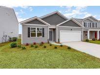 Charming single-story home featuring manicured lawn and a two-car garage at 4485 East Coast Ln., Shallotte, NC 28470