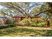 Charming home with a rustic exterior, featuring a lush front lawn and mature trees offering shade and curb appeal at 509 14Th Ave. S, North Myrtle Beach, SC 29582