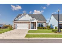 Charming single-story home boasts a stone facade, attached two-car garage, and manicured front lawn at 615 Shortleaf Path, Myrtle Beach, SC 29577