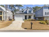 Charming two-story home featuring a light gray exterior, well-manicured lawn, and attached garage at 626 5Th Ave. S, Surfside Beach, SC 29575