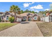 Charming brick home with a well-manicured lawn, large driveway and mature landscaping at 129 Waterfall Circle, Little River, SC 29566