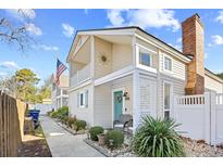 Charming two-story home featuring a quaint front porch and neatly landscaped yard at 1902-B Hillside Dr. S., North Myrtle Beach, SC 29582