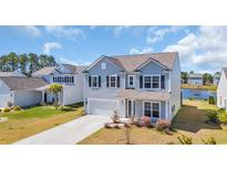 Charming two-story home with light blue siding, black shutters, and a well-manicured lawn at 3304 Candytuft Dr., Conway, SC 29526