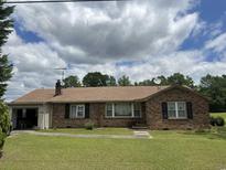 Charming brick home with an attached garage and well-maintained lawn, perfect for suburban living at 3328 Rose Hill Rd., Georgetown, SC 29440