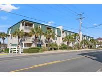 A bright shot of the condo building at The Waves in Myrtle Beach, South Carolina, with palm trees at 4201 N Ocean Blvd. # I3, North Myrtle Beach, SC 29582