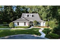 Charming home featuring manicured lawn, lush landscaping, and a welcoming walkway leading to the front door at 50 Painted Bunting Ct., Pawleys Island, SC 29585