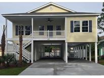 Inviting coastal home with covered parking, front porch, and staircase at 605 15Th Ave. S, North Myrtle Beach, SC 29582